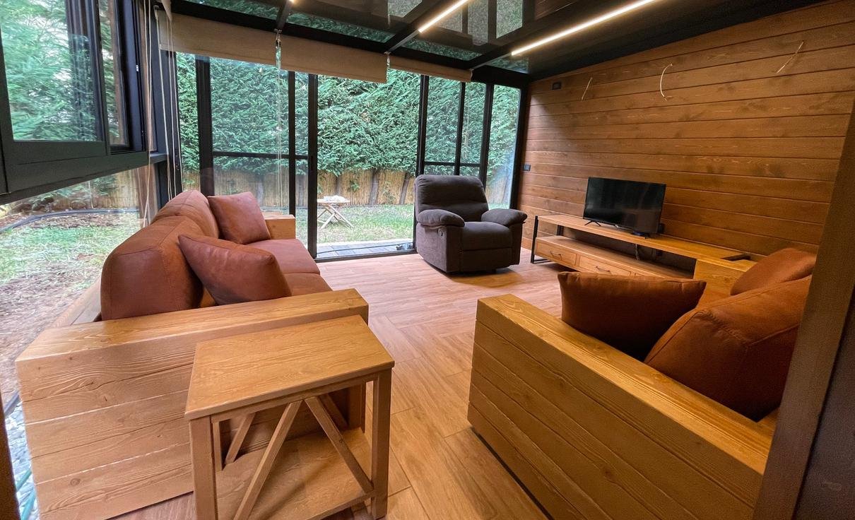 Bungalow lounge with wood cladding and panoramic window