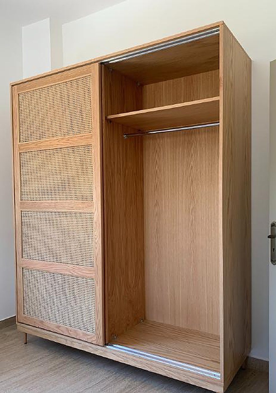 Open oak wardrobe with rattan sliding doors