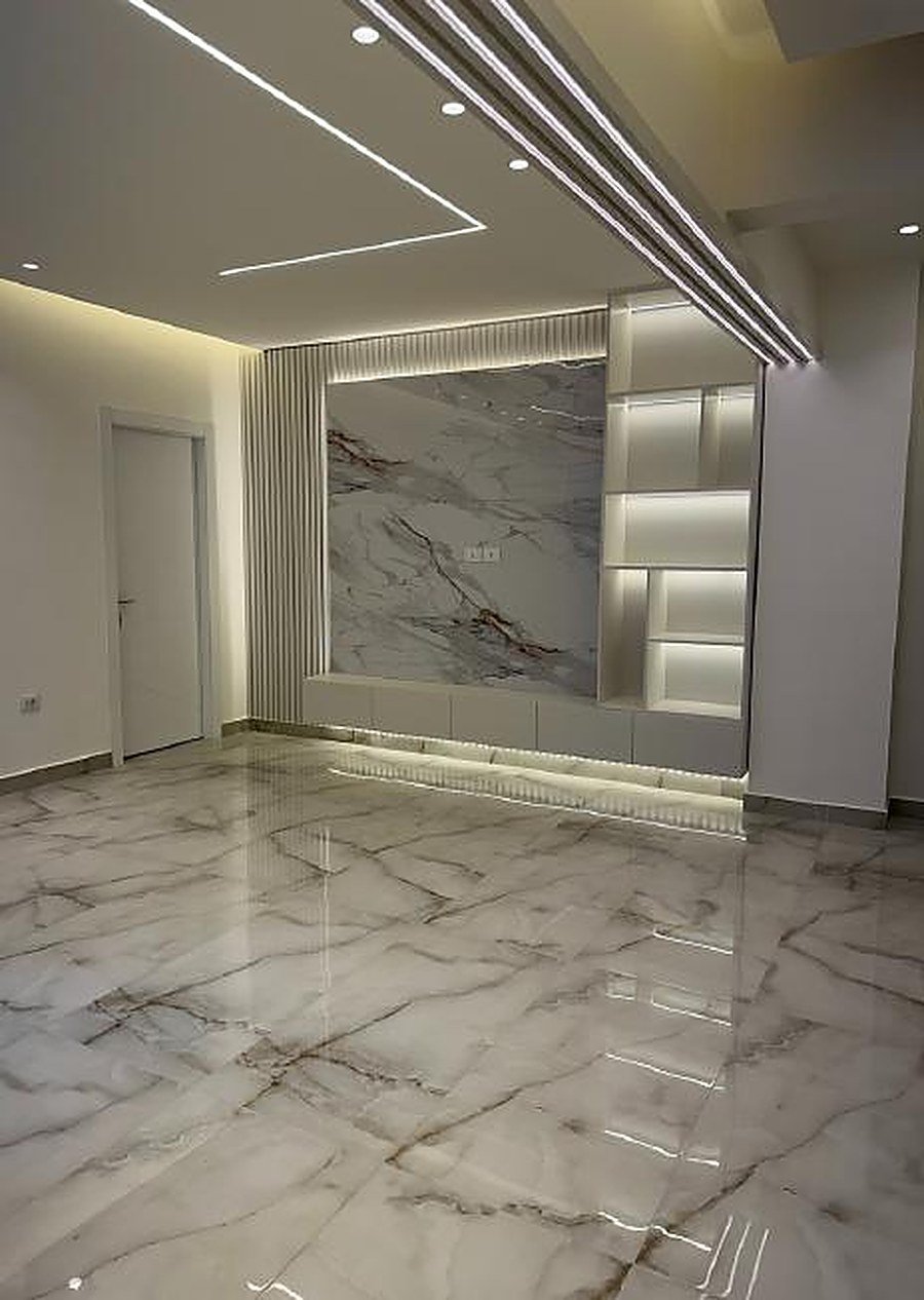 TV wall with floating shelves and warm oak slats