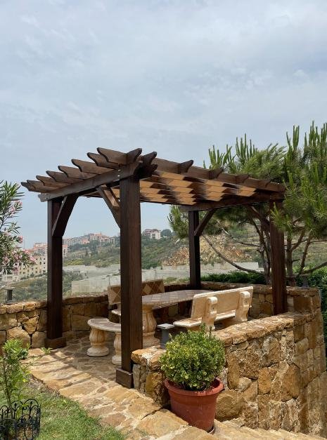 Rustic dark pergola with mountain village view