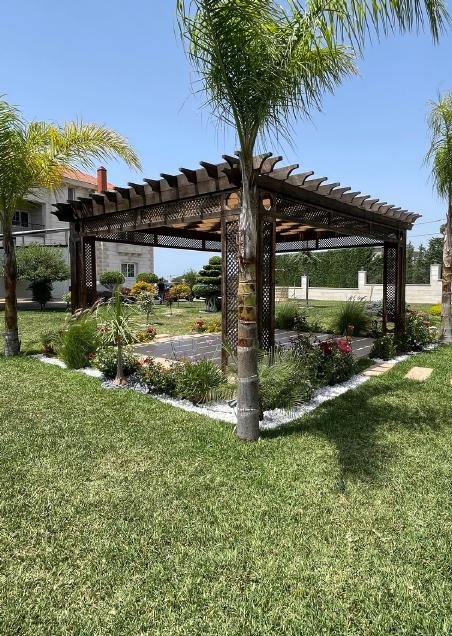 Ornate lattice-top garden pergola with plants